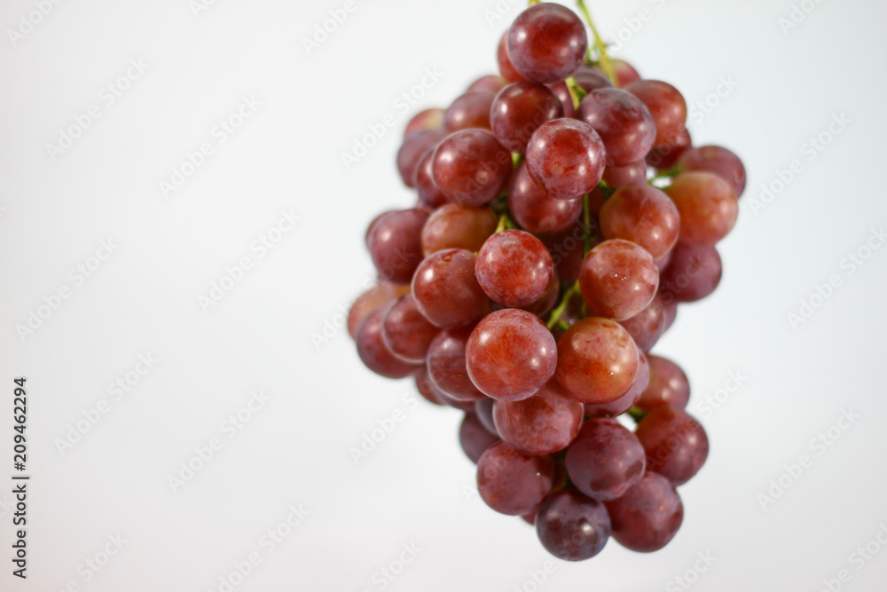 Red grapes on white background.