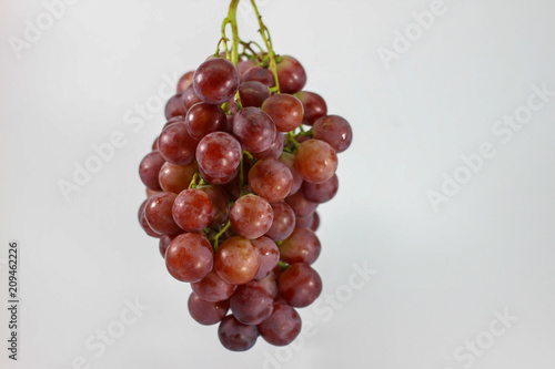 Red grapes on white background.