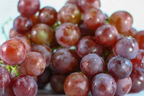 Red grapes on white background.