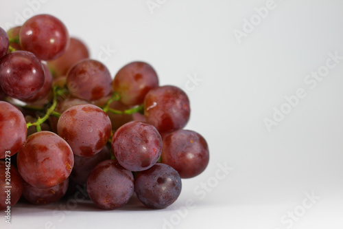 Red grapes on white background.