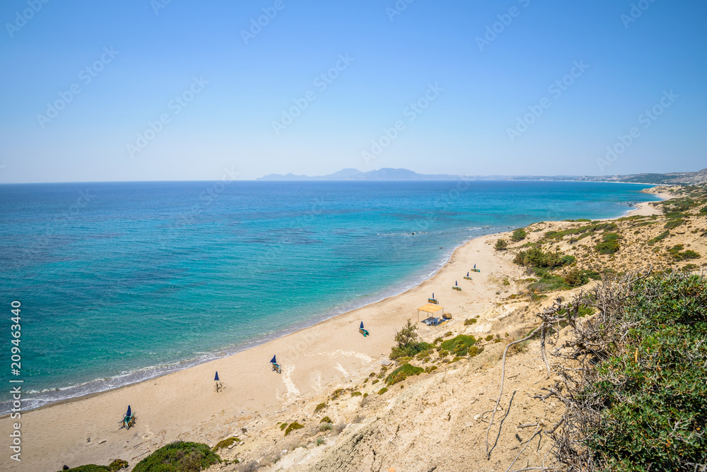 Beaches, Greece, Kos Island, Cap Helona: beautiful holiday setting on a secluded beach with umbrellas on the Greek Aegean Sea with turquoise waters and a picturesque bay and islands in the background