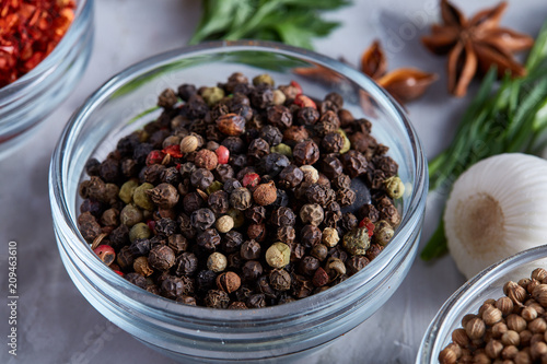 Peppercorns in wooden spoon with clipping path on white textured background, close-up, selective focus.