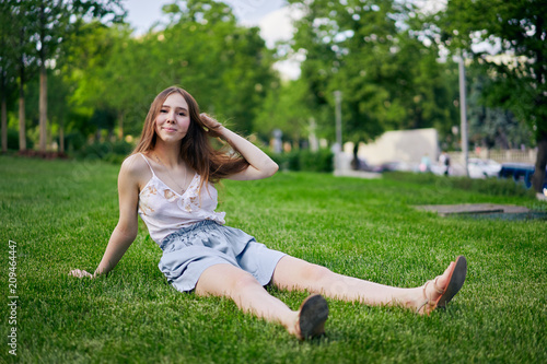 Young girl in the summer sitting on the grass