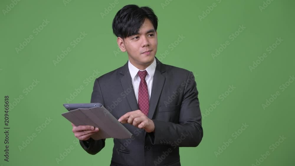 Young handsome Asian businessman using digital tablet Young handsome Asian businessman using digital tablet
