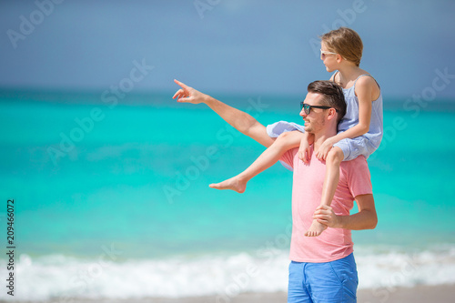 Family of father and sporty little girl having fun on the beach