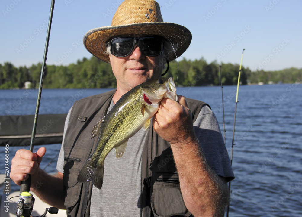 Happy Fisherman holding up a caught Large Mouth Bass Happy Fisherman holding up a caught Large Mouth Bass