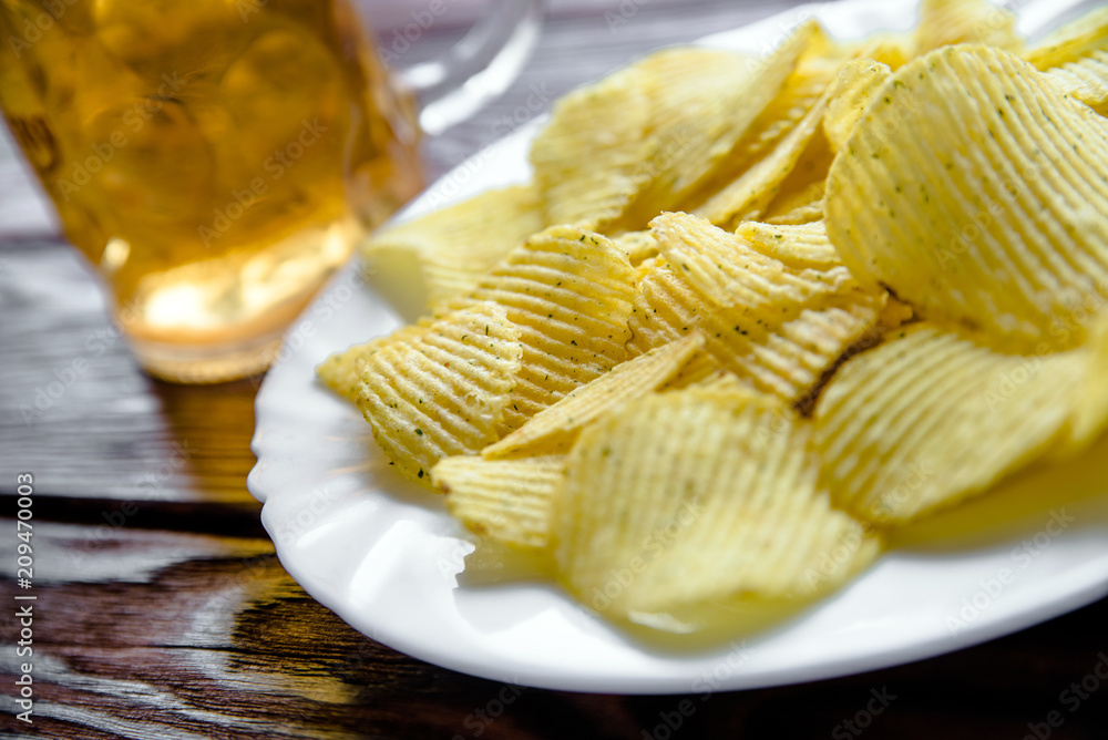 Potato chips and beer on a wooden table Potato chips and beer on a wooden table