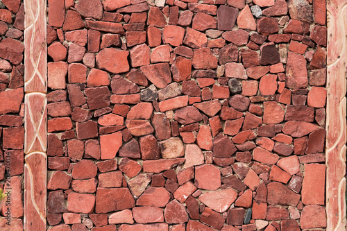 old wall of a large red stone. Masonry made of large red stone on archaeological excavations. old wall in the ancient city. background from natural stones, place for text