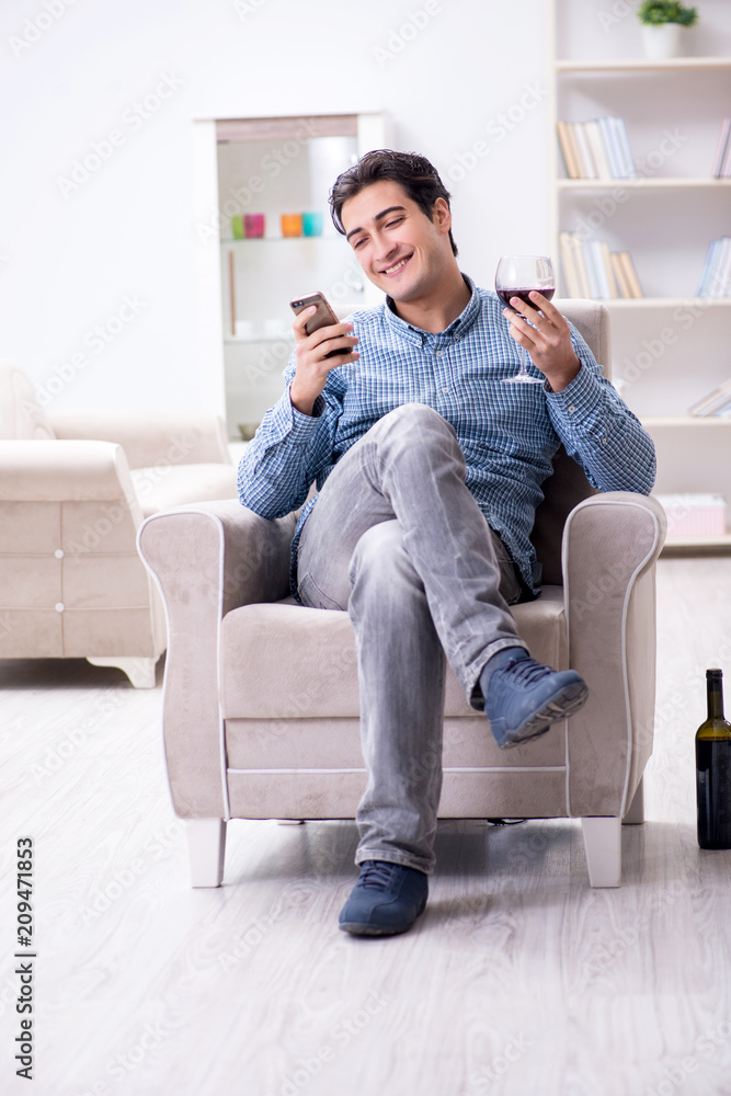 Young man drinking wine at home Young man drinking wine at home