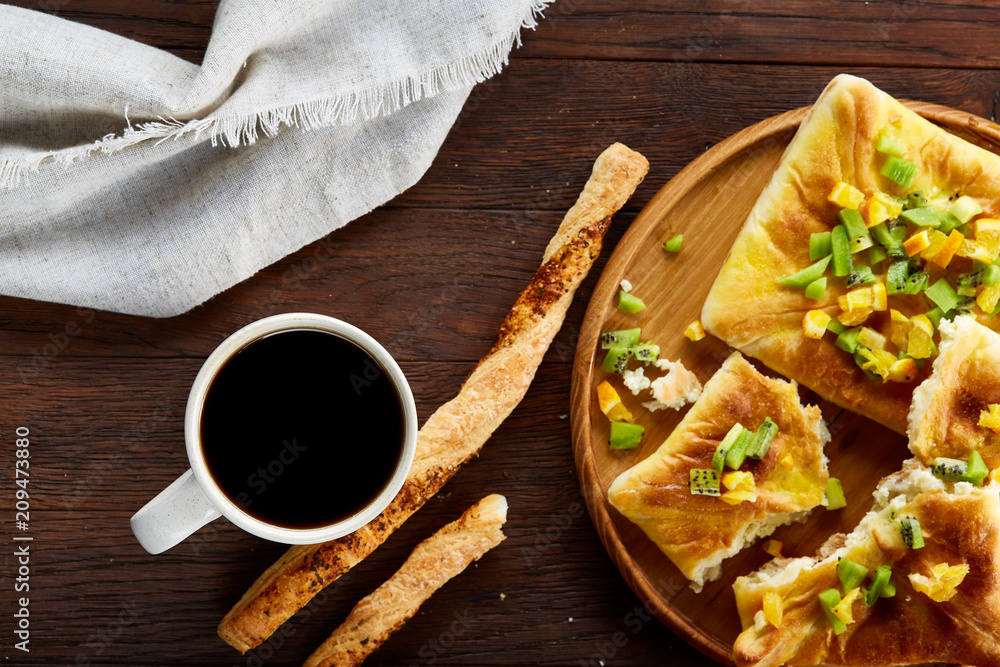 Morning concept with a cup of coffee, breadsticks, fruit pies and oranges on wooden background. Morning concept with a cup of coffee, breadsticks, fruit pies and oranges on wooden background.