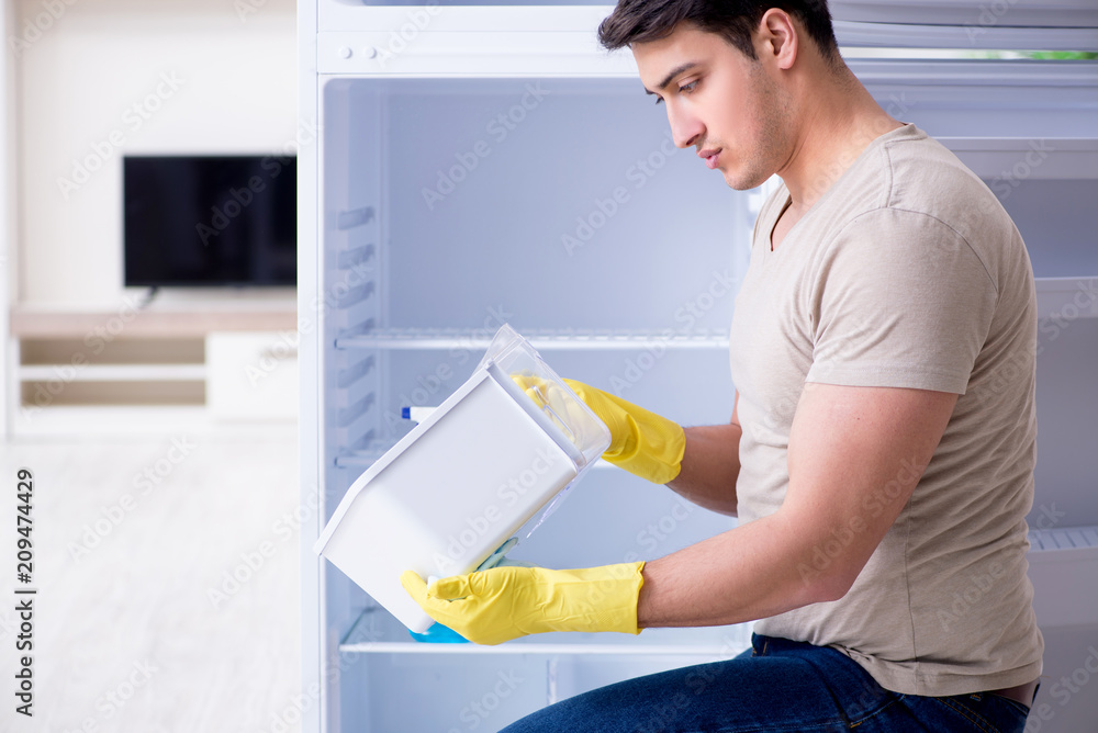 Man cleaning fridge in hygiene concept