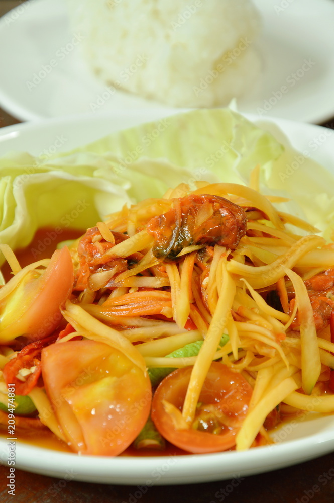 Som tum Thai spicy green papaya with pickled mussel salad eat couple sticky rice on plate Som tum Thai spicy green papaya with pickled mussel salad eat couple sticky rice on plate