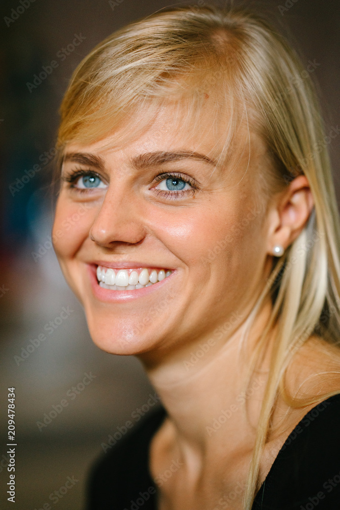 Close-up portrait head shot of a young and attractive blond woman with blue eyes. She is casually and comfortably dressed and is smiling as she looks off camera. Close-up portrait head shot of a young and attractive blond woman with blue eyes. She is casually and comfortably dressed and is smiling as she looks off camera.