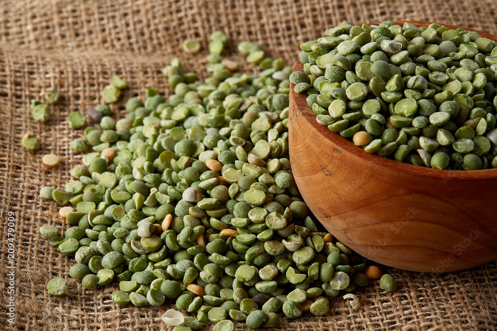 An overturned bowl with green peas on burlap tablecloth, close-up, top view, selective focus, shallow depth of field. An overturned bowl with green peas on burlap tablecloth, close-up, top view, selective focus, shallow depth of field.