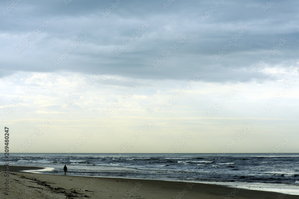 Maritime landscape with man walking on the beach