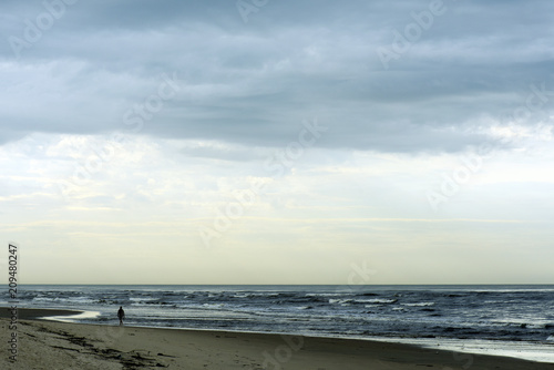 Fototapeta Naklejka Na Ścianę i Meble -  Maritime landscape with man walking on the beach