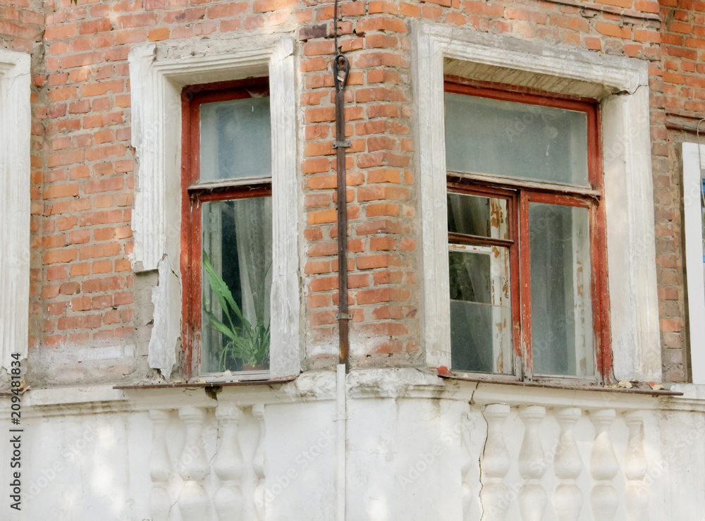 Windows on the wall of an old brick house with architectural decor Windows on the wall of an old brick house with architectural decor