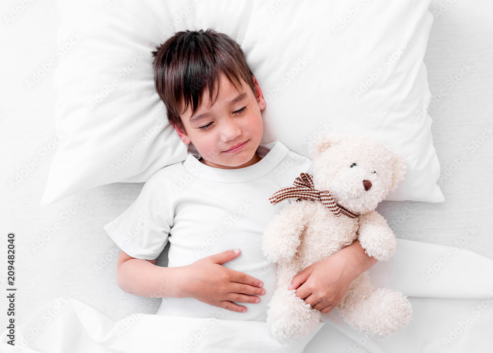 Toddler boy sleeping with teddy bear