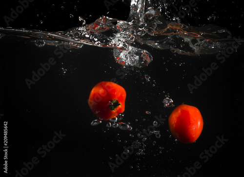 Tomatoes in the water with black background