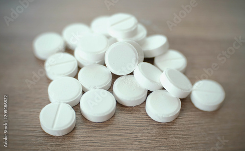 Pile of round white tablets on the table.