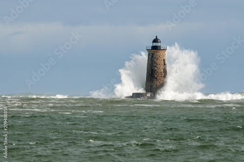 Large Wave Covers Stone Lighthouse Tower in Maine