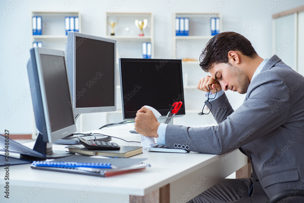 Businessman sitting in front of many screens Businessman sitting in front of many screens