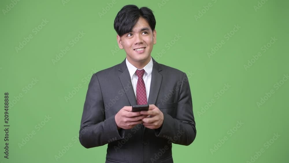 Young handsome Asian businessman using mobile phone Young handsome Asian businessman using mobile phone