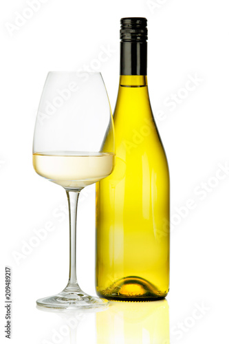 A glass of white wine and a bottle.
