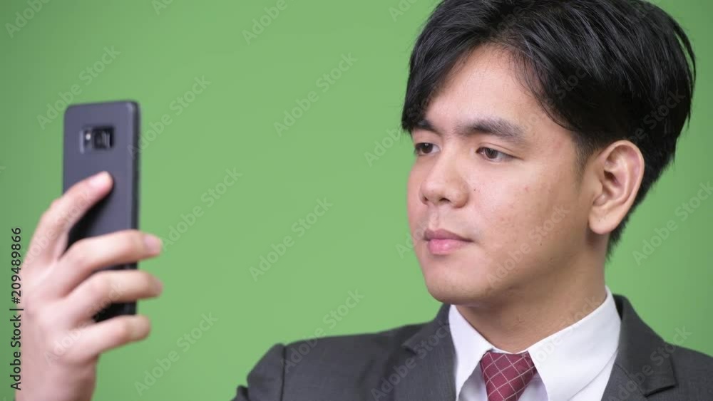 Young handsome Asian businessman using mobile phone Young handsome Asian businessman using mobile phone