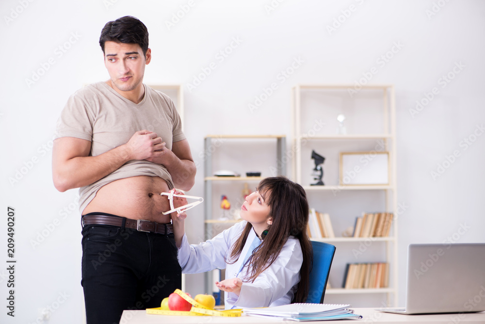 Doctor dietician giving advices to fat overweight patient Doctor dietician giving advices to fat overweight patient