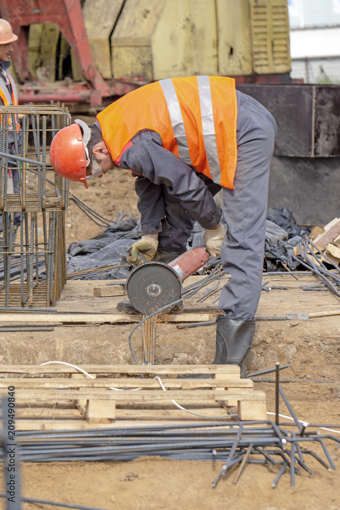 Khimki, Russia - June 14, 2018: Worker at the construction site sawing Khimki, Russia - June 14, 2018: Worker at the construction site sawing