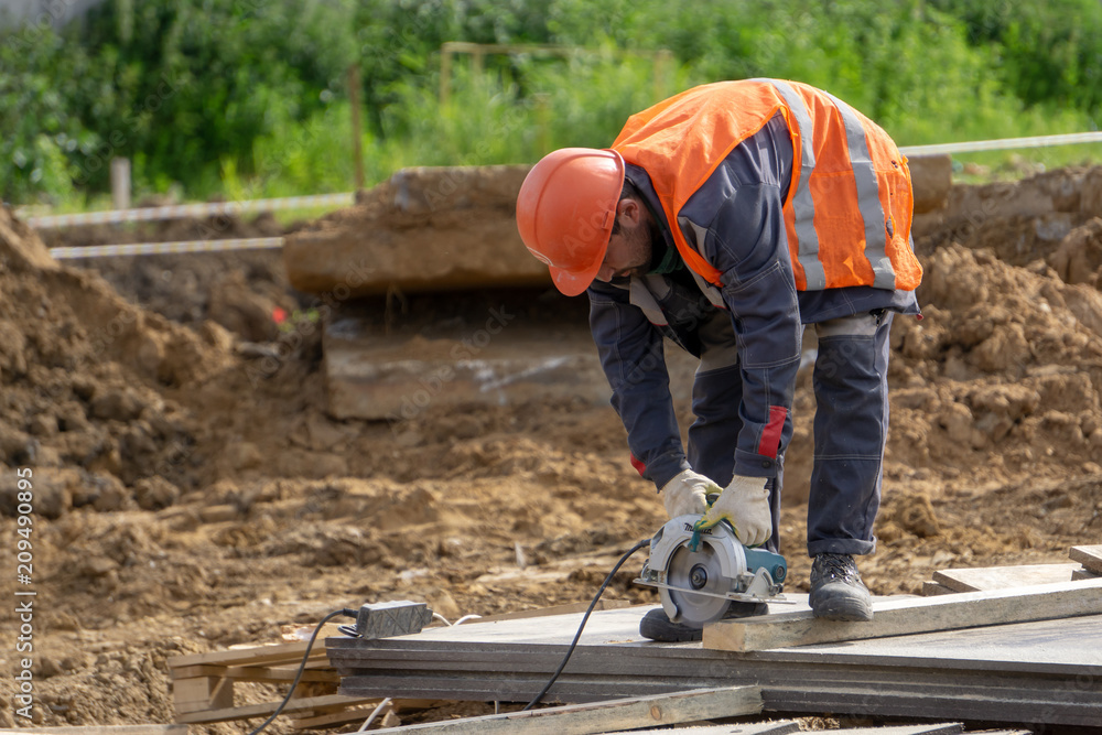 Khimki, Russia - June 14, 2018: Worker at the construction site sawing Khimki, Russia - June 14, 2018: Worker at the construction site sawing