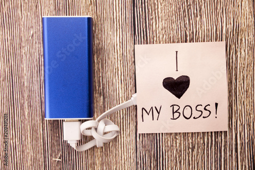 Power Bank with a piece of paper around, having words I Love my boss is present.Love for an officer, head or boss is mentioned in the image. Business Concept is shown in picture. photo