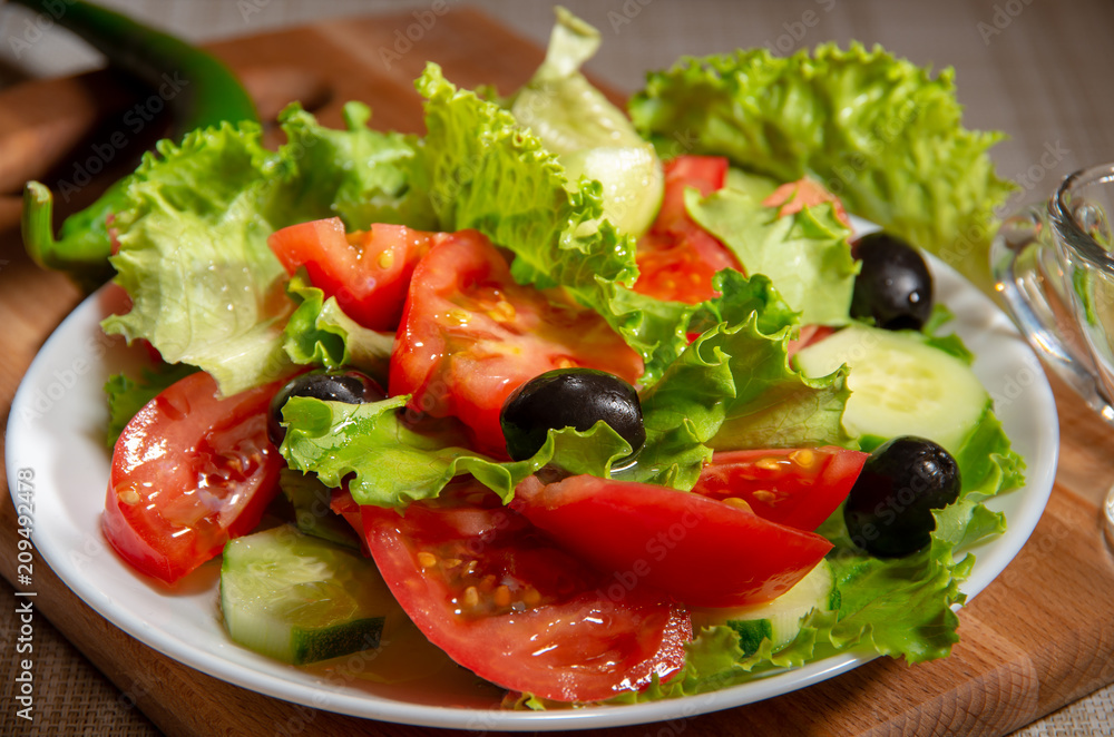 Raw salad of tomatoes, olives and cucumbers Raw salad of tomatoes, olives and cucumbers