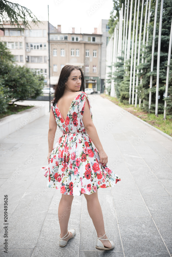 young beautiful woman in colorful dress looking over shoulder young beautiful woman in colorful dress looking over shoulder