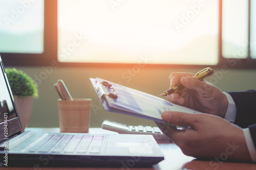 A dignified businesswoman analyzing information in the office and having morning sunshine.