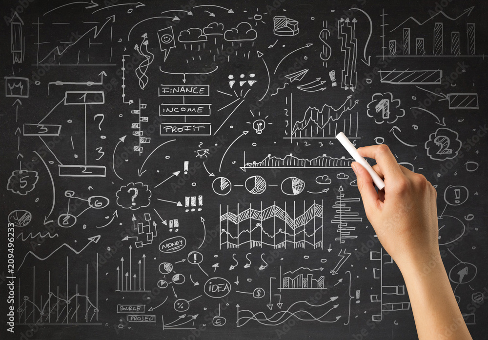 Female hand holding white chalk in front of a blackboard with a business plan drawn on it Female hand holding white chalk in front of a blackboard with a business plan drawn on it