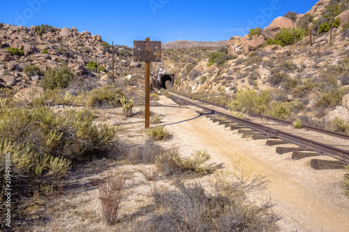 Blank sign near train tracks and tunnel