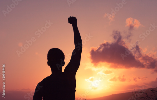 Feeling motivated and winning concept. silhouette of fit male with fist in the air. 