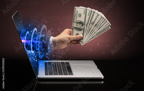Hand with money coming out of a laptop with sparkling effects
