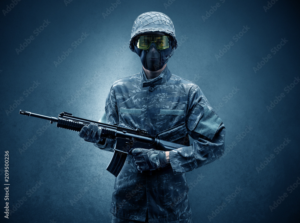 Soldier agent in a dark room with arms on his hand and gas mask
