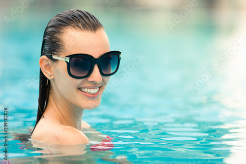 Portrait of attractive female relaxing in swimming pool. 