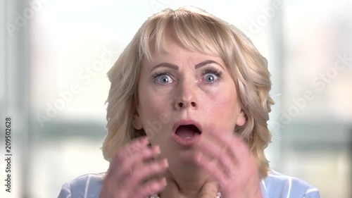 Face of shocked terrified woman. Female face with wide opened eyes and mouth expressing shock and horror. Negative human emotions and facial expressions.