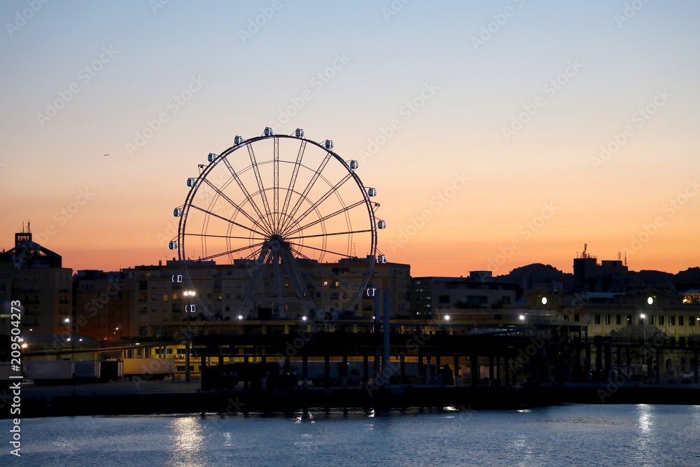 View of Malaga harbor with Ferris wheel at sunset, Malaga, Andalusia, Spain