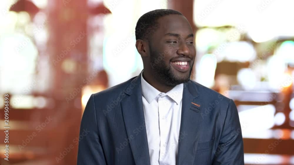 Happy confused afro-american businessman. Smiling stunned african-american manager on blurred background. Dark-skinned guy with positive face expressions. Happy confused afro-american businessman. Smiling stunned african-american manager on blurred background. Dark-skinned guy with positive face expressions.