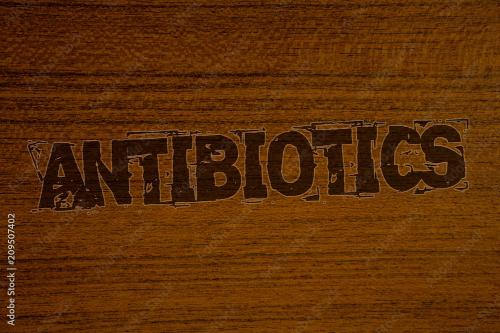 Conceptual hand writing showing Antibiotics. Business photos showcasing Drug used in treatment and prevention of bacterial infectionsBold brown letters words ideas on wooden background.