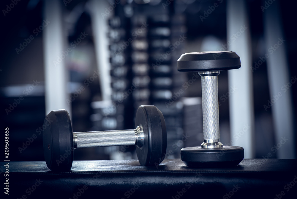 Close up of modern dumbbells equipment in the sport gym , gym equipment concept.