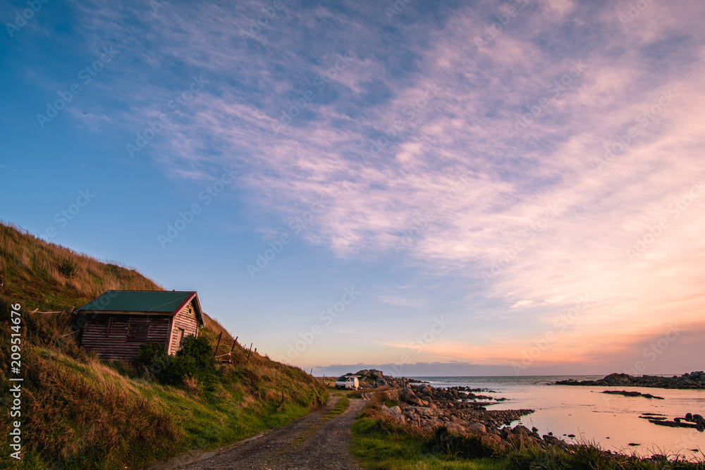 Beautiful scene of a landscape in a rural area beside the ocean at sunset. Cosy Nook, New Zealand.