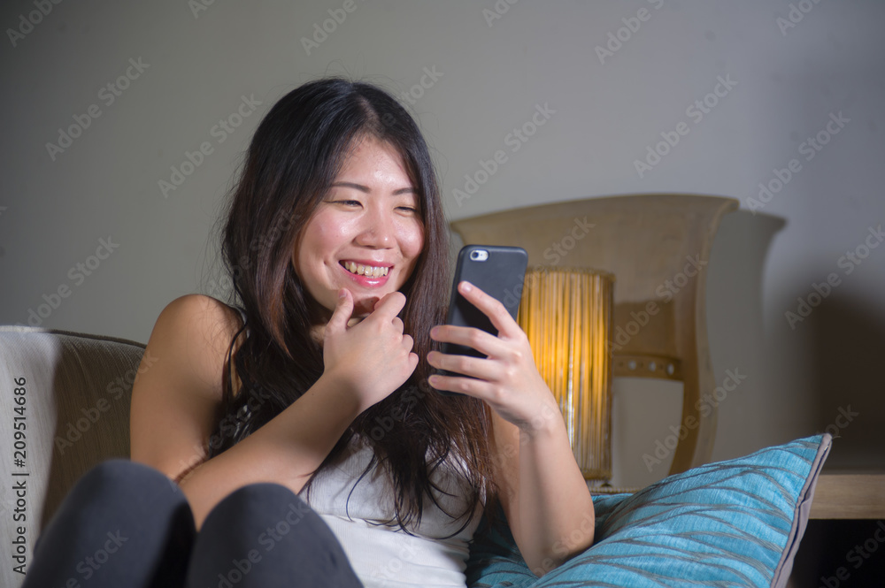 young sweet happy and pretty Asian Korean woman using internet social media app on mobile phone smiling cheerful having fun at home sofa couch young sweet happy and pretty Asian Korean woman using internet social media app on mobile phone smiling cheerful having fun at home sofa couch