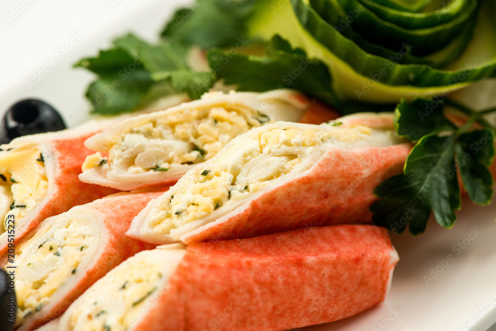 Crab sticks with lettuce and dill on brown wooden cutting board Crab sticks with lettuce and dill on brown wooden cutting board